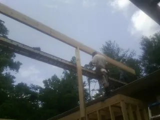 Carpenter setting a ridge beam over a new addition frame — Ice Dam Removal by Roofing Brothers in Dittmer