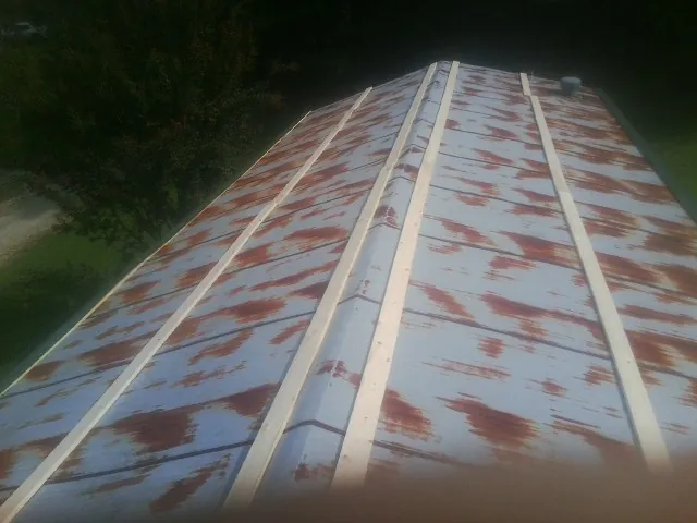 Rusted metal roof panels with new wood purlins before replacement — Storm Damage Roof Repair in Dittmer by Roofing Brothers
