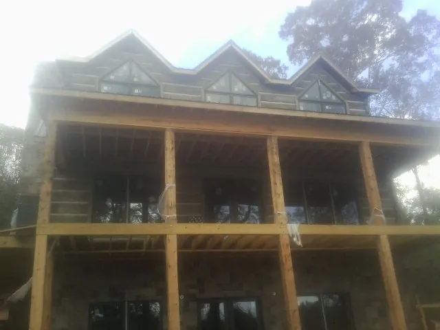 Dormers and porch framing on a large log home under construction — Roof Coating work by our crew in Dittmer