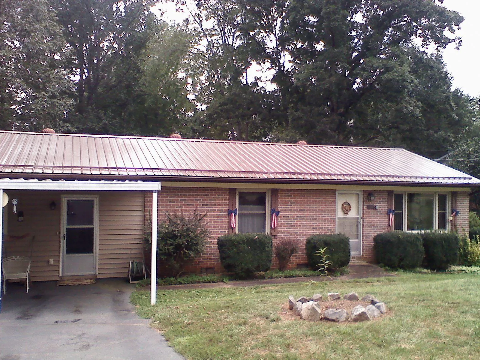 Bronze metal roof and carport on a brick ranch home — Roof Repair work by our crew in Dittmer